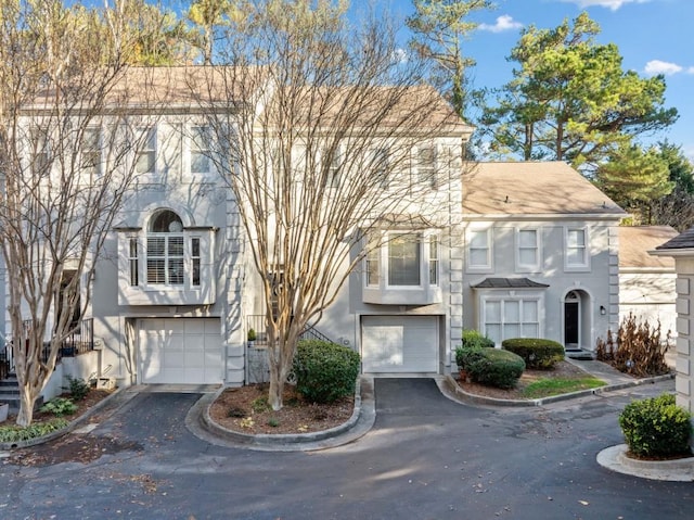 view of front of home featuring aphalt driveway, an attached garage, and stucco siding