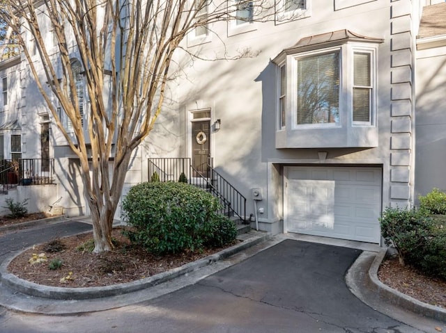 property entrance featuring driveway, a garage, and stucco siding