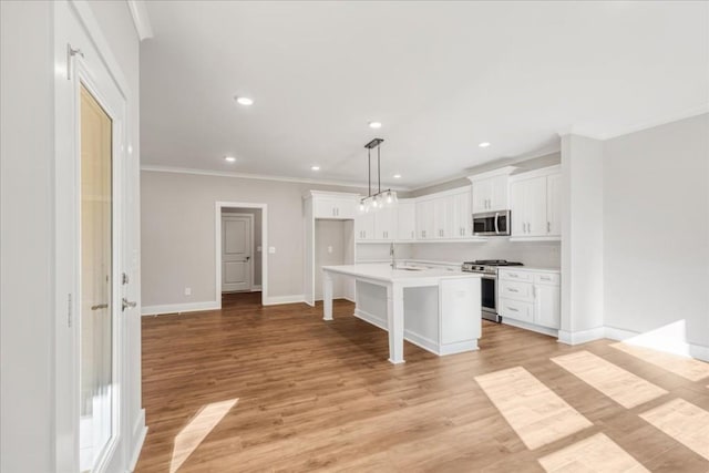 kitchen featuring sink, decorative light fixtures, a kitchen island, white cabinetry, and stainless steel appliances