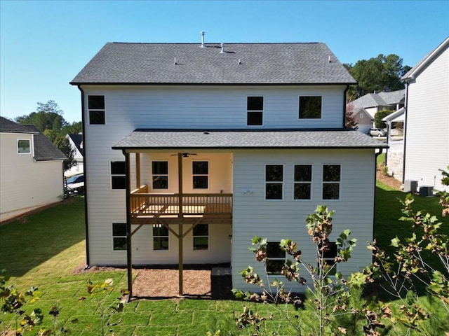 rear view of property featuring a wooden deck, ceiling fan, and a yard