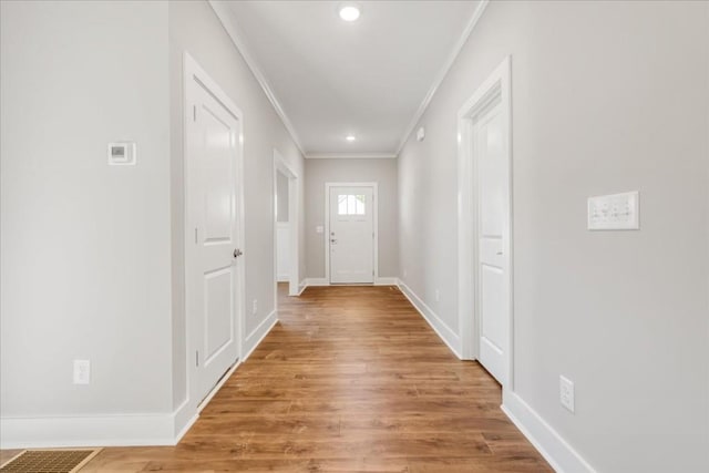 entryway with crown molding and wood-type flooring