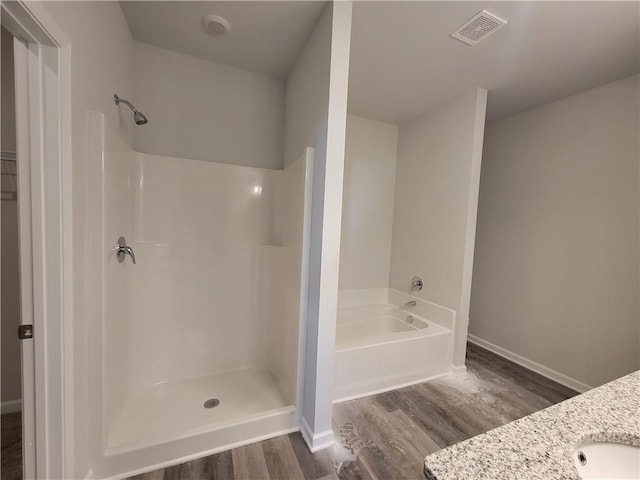 bathroom featuring hardwood / wood-style flooring, independent shower and bath, and vanity