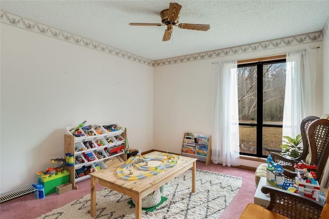 rec room featuring ceiling fan, a textured ceiling, and carpet flooring