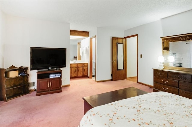 carpeted bedroom featuring a textured ceiling and ensuite bath