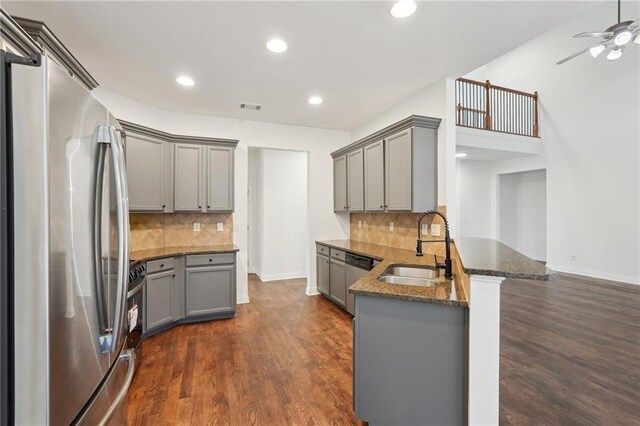 kitchen with stainless steel appliances, visible vents, gray cabinetry, a sink, and a peninsula