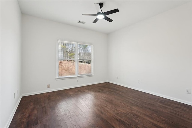 unfurnished room featuring dark wood-style flooring, visible vents, ceiling fan, and baseboards