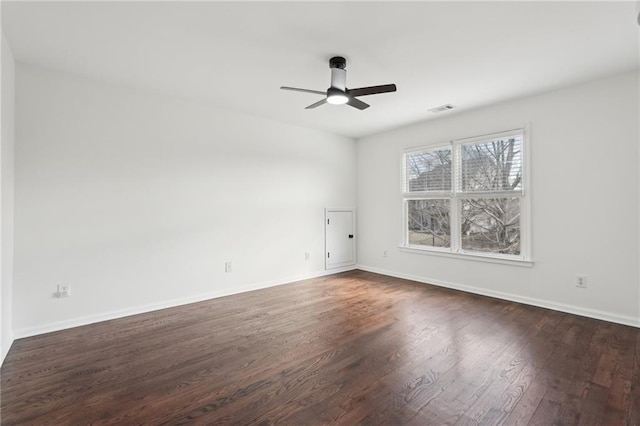 unfurnished room with baseboards, visible vents, dark wood finished floors, and a ceiling fan