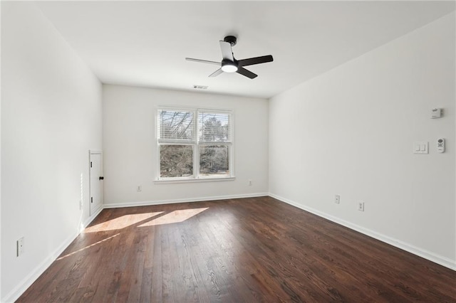 empty room featuring a ceiling fan, dark wood-style flooring, visible vents, and baseboards