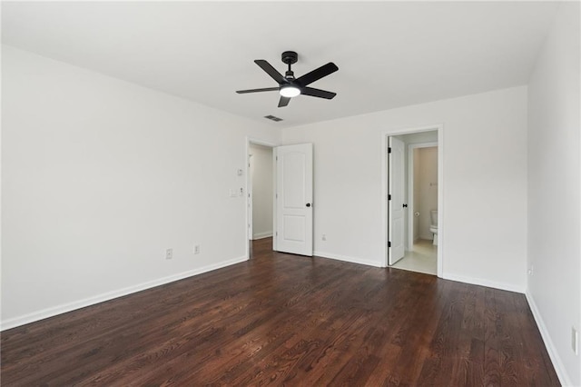 unfurnished bedroom with ceiling fan, connected bathroom, dark wood-style flooring, visible vents, and baseboards