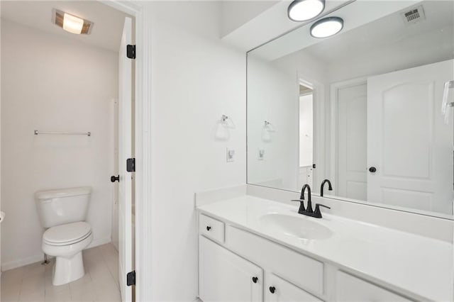 bathroom with visible vents, toilet, vanity, tile patterned flooring, and baseboards