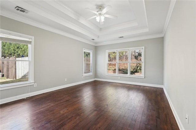 spare room featuring ceiling fan, visible vents, baseboards, dark wood-style floors, and a raised ceiling