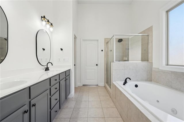 bathroom with a stall shower, a sink, a wealth of natural light, and tile patterned floors