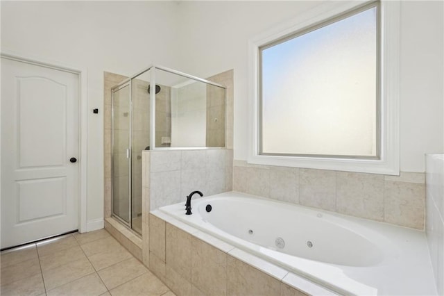 bathroom with tile patterned flooring, a shower stall, and a tub with jets