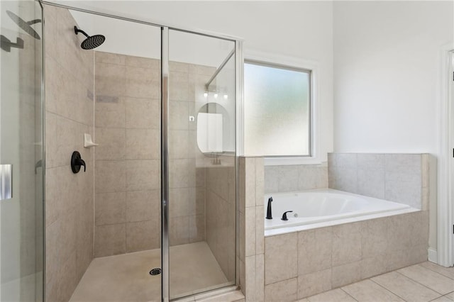 bathroom featuring tile patterned flooring, a shower stall, and a bath