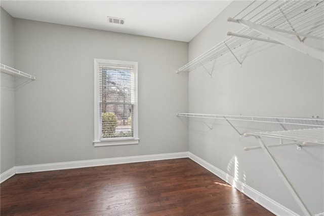 spacious closet featuring dark wood-style flooring and visible vents