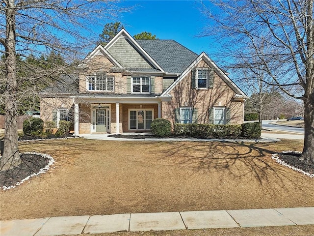 craftsman-style home with covered porch and brick siding