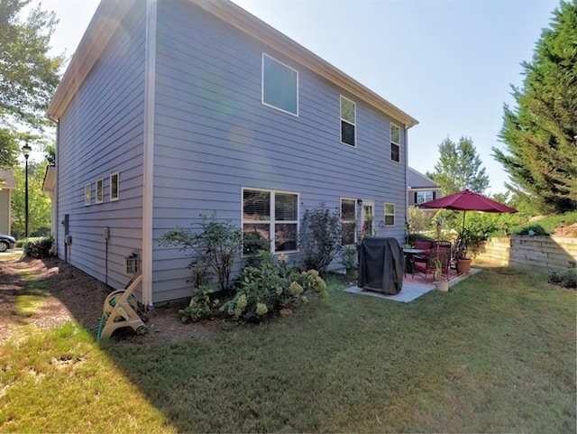 rear view of property with a yard and a patio area