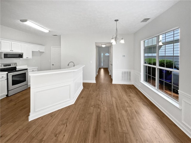 3968 Oak Glenn Dr, Duluth, GA 30096 - kitchen with stainless steel appliances, wood finished floors, white cabinets, a chandelier, and a textured ceiling