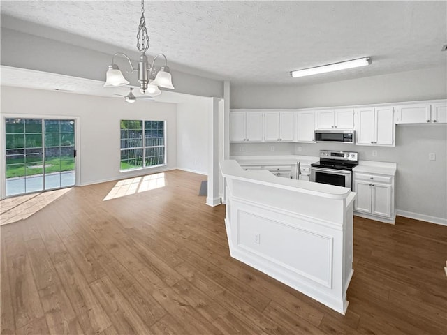3968 Oak Glenn Dr, Duluth, GA 30096 - kitchen with stainless steel appliances, a chandelier, white cabinetry, dark wood finished floors, and a textured ceiling