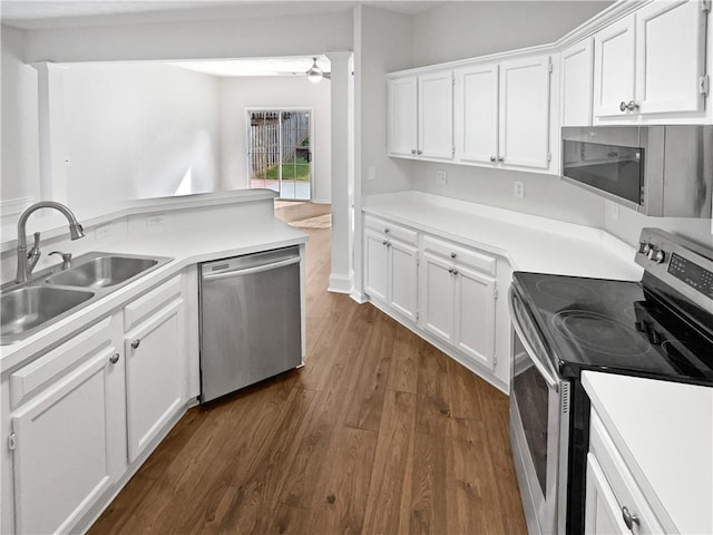 3968 Oak Glenn Dr, Duluth, GA 30096 - kitchen with stainless steel appliances, a sink, dark wood-style floors, white cabinets, and light countertops