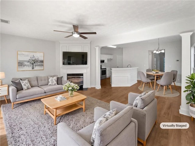 3968 Oak Glenn Dr, Duluth, GA 30096 - living area featuring ceiling fan, wood finished floors, ornate columns, and a chandelier