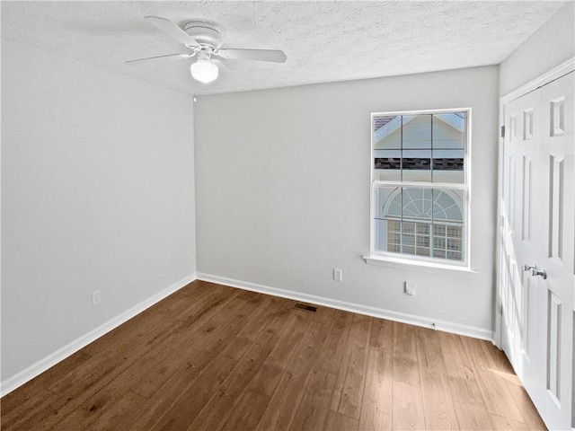 3968 Oak Glenn Dr, Duluth, GA 30096 - spare room with wood finished floors, baseboards, a ceiling fan, and a textured ceiling