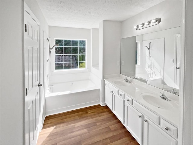 3968 Oak Glenn Dr, Duluth, GA 30096 - full bath with wood finished floors, a tub, a textured ceiling, double vanity, and a shower