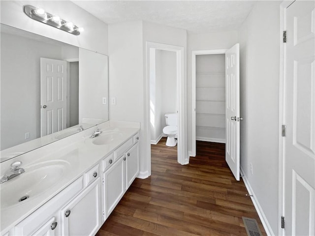 3968 Oak Glenn Dr, Duluth, GA 30096 - bathroom featuring wood finished floors, toilet, double vanity, and baseboards