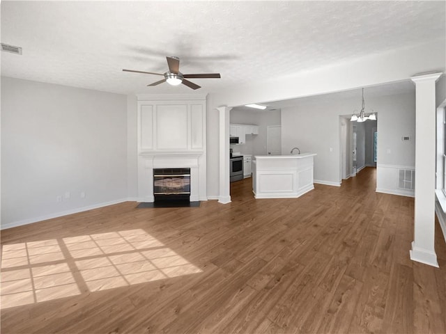 3968 Oak Glenn Dr, Duluth, GA 30096 - unfurnished living room with ceiling fan, a chandelier, a textured ceiling, a large fireplace, and wood finished floors