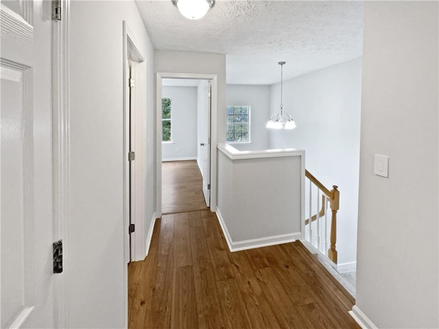 3968 Oak Glenn Dr, Duluth, GA 30096 - corridor with an upstairs landing, dark wood finished floors, baseboards, a chandelier, and a textured ceiling