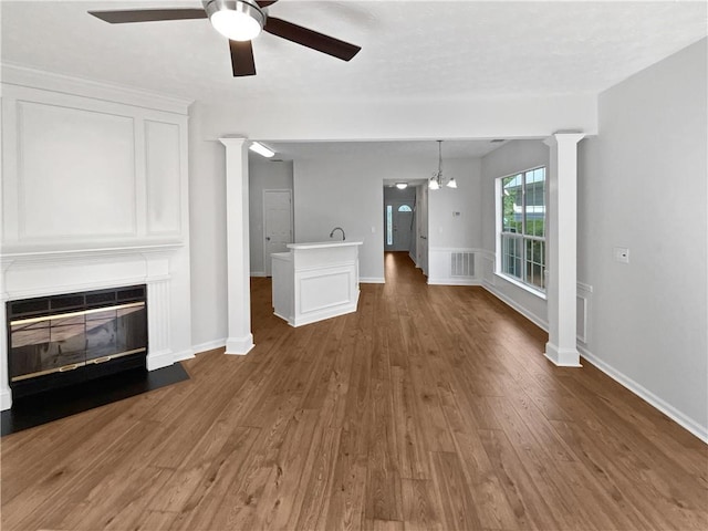 3968 Oak Glenn Dr, Duluth, GA 30096 - unfurnished living room featuring a ceiling fan, wood finished floors, a fireplace with flush hearth, ornate columns, and baseboards