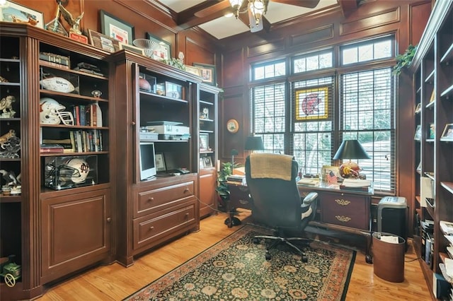 office featuring crown molding, a decorative wall, light wood-style floors, ceiling fan, and coffered ceiling