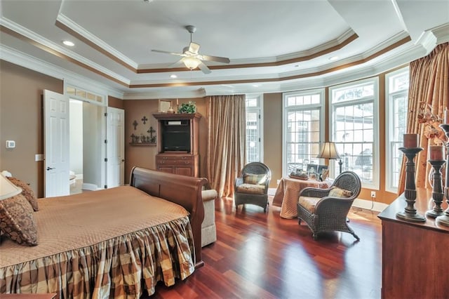 bedroom featuring baseboards, ornamental molding, a raised ceiling, and wood finished floors