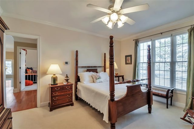 bedroom with light carpet, baseboards, ornamental molding, and a ceiling fan