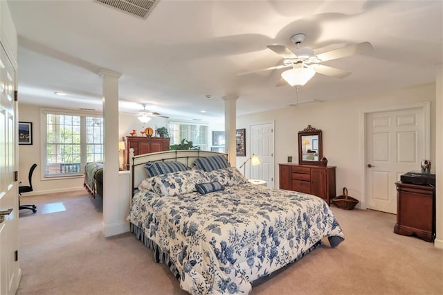 bedroom with light carpet, decorative columns, visible vents, and a ceiling fan