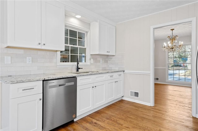 kitchen featuring a sink, visible vents, light wood-style floors, and dishwasher