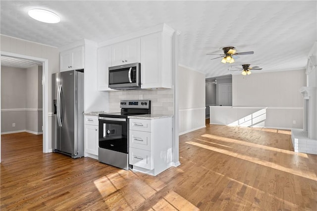 kitchen with white cabinetry, decorative backsplash, wood finished floors, and stainless steel appliances