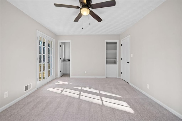 carpeted empty room featuring baseboards, visible vents, and ceiling fan