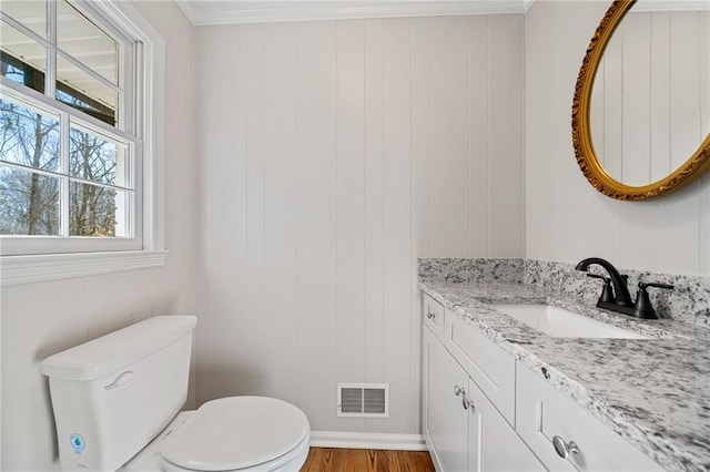 bathroom featuring vanity, toilet, wood finished floors, and visible vents