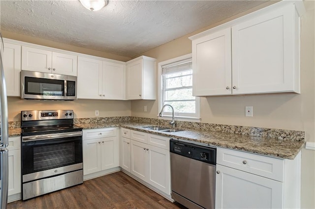 3018 Meadowview Dr SE, Atlanta, GA 30316 - kitchen featuring sink, white cabinetry, stainless steel appliances, light stone countertops, and dark hardwood / wood-style flooring