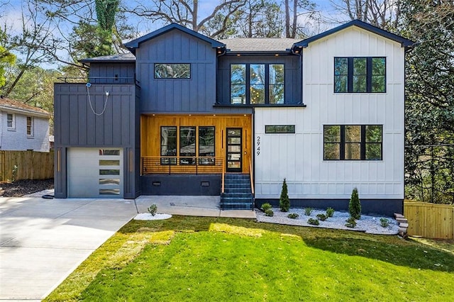 modern farmhouse style home with a front lawn, an attached garage, fence, and driveway