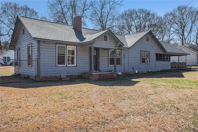 view of front of home with a chimney, roof with shingles, fence, cooling unit, and a front lawn