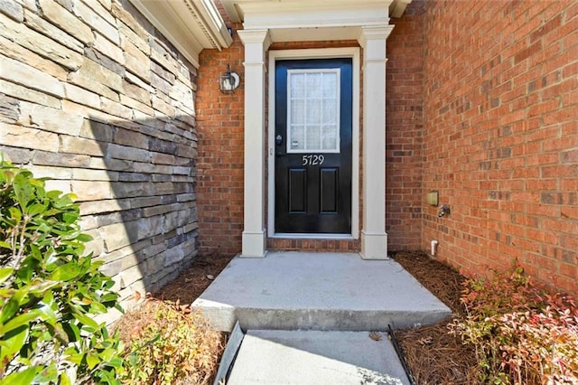 view of exterior entry with brick siding