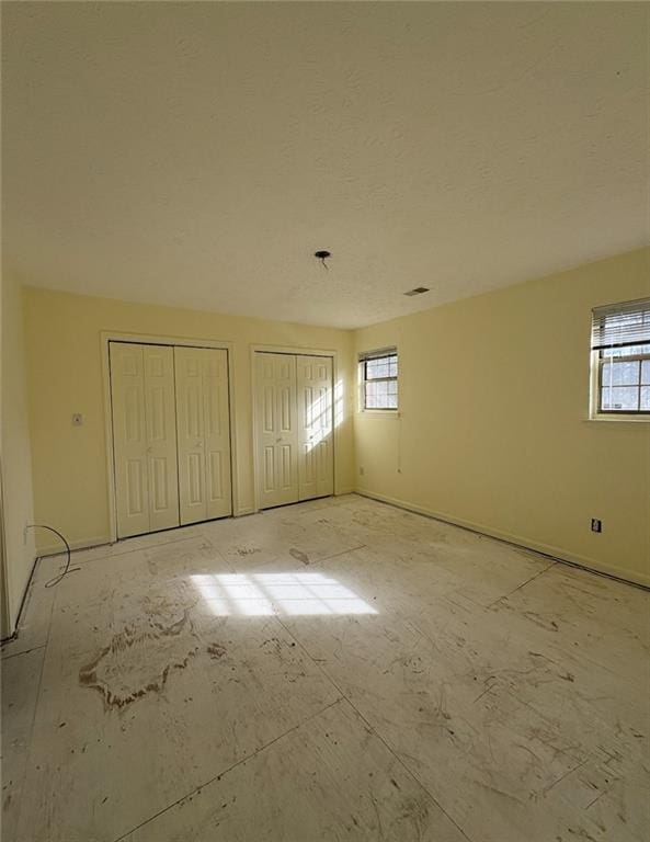 7123 Williamsburg Dr, Riverdale, GA 30274 - unfurnished bedroom featuring multiple windows and multiple closets