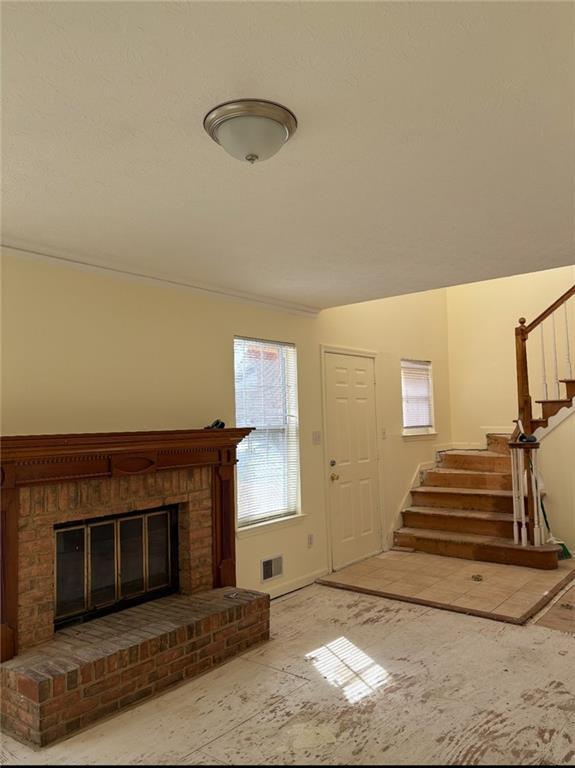 7123 Williamsburg Dr, Riverdale, GA 30274 - unfurnished living room with baseboards, stairway, and a fireplace