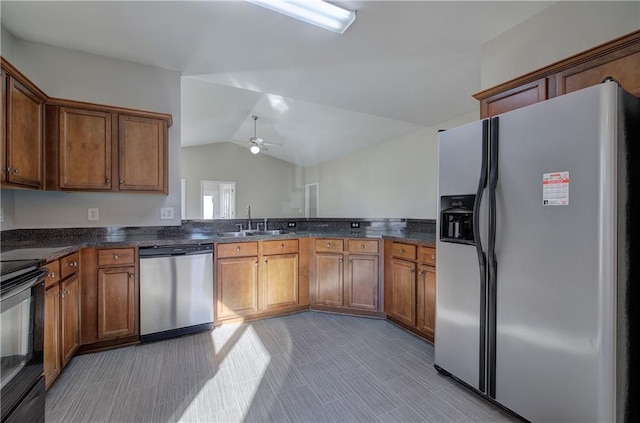 kitchen with appliances with stainless steel finishes, ceiling fan, sink, dark stone countertops, and lofted ceiling