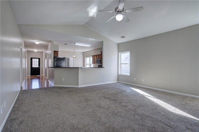 unfurnished living room featuring dark colored carpet, ceiling fan, and lofted ceiling