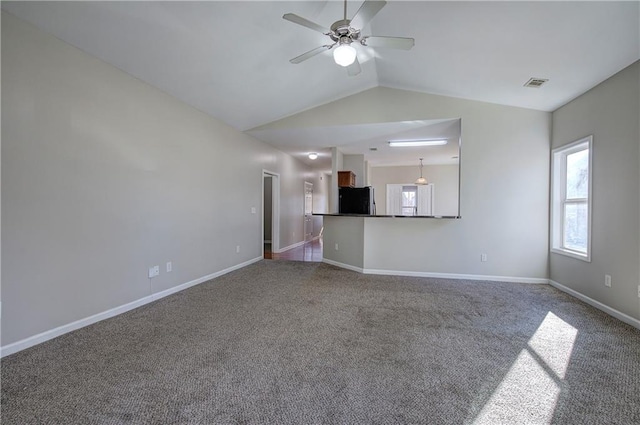 unfurnished living room with carpet flooring, ceiling fan, and vaulted ceiling