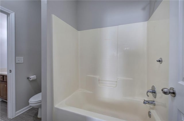 full bathroom featuring washtub / shower combination, vanity, and toilet