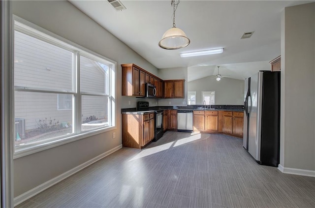 kitchen featuring stainless steel appliances, vaulted ceiling, ceiling fan, sink, and hanging light fixtures